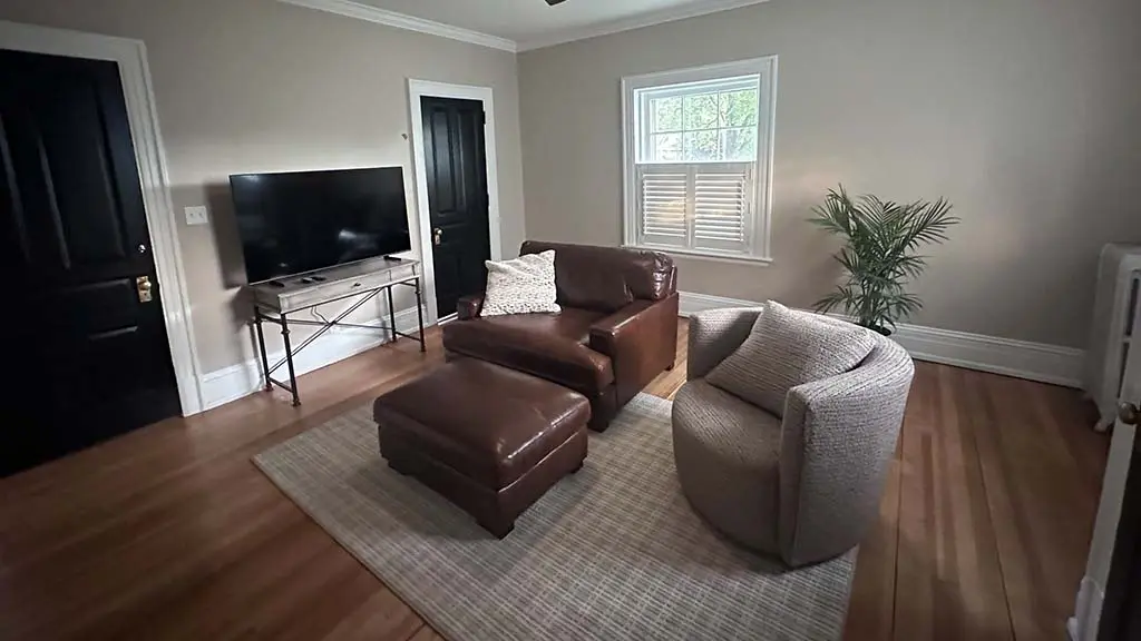 cozy living room featuring painted greige walls white baseboards and trim and contrasting black interior doors